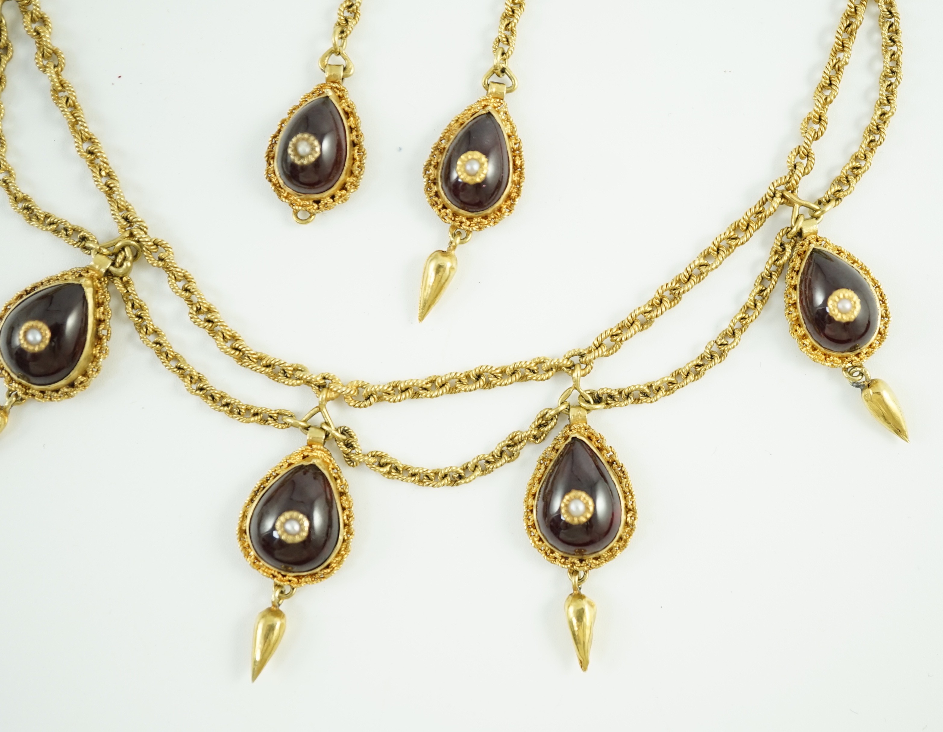 A 19th century Indian gold, garnet and seed pearl set demi parure, comprising and a drop fringe necklace and pair of matching ear clips